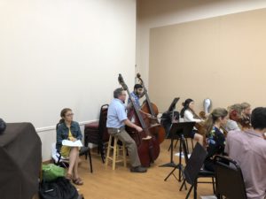 upright bass players in room with group