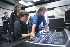 people standing over sound board